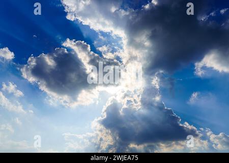 Fasci di sole che si infrangono tra le spettacolari nuvole di cumulus. Il tempo cambia da tempesta a soleggiata. Concetto di speranza o religione. Foto Stock