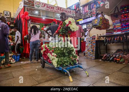 Nairobi, Kenya. 14 febbraio 2024. Un uomo keniota consegna fiori in un negozio del mercato cittadino di Nairobi durante il giorno di San Valentino a Nairobi. I kenioti riempivano varie strade in tutto il paese mentre celebravano San Valentino nonostante la dura situazione economica che si sta attualmente vivendo. Anche i fioristi e i negozi di articoli da regalo sparsi in tutta la città di Nairobi hanno registrato un aumento del traffico, mentre i kenioti colsero il momento di acquistare regali e cestini per i loro cari. Il Kenya è un grande esportatore di fiori in Europa e in Medio Oriente. Credito: SOPA Images Limited/Alamy Live News Foto Stock
