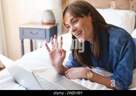 Una donna caucasica di mezza età sta effettuando una videochiamata sul suo laptop Foto Stock