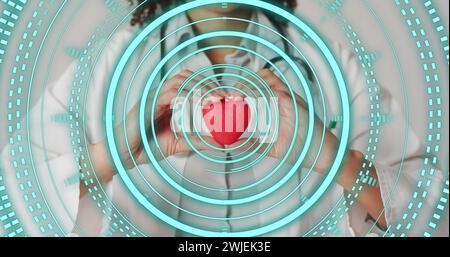 Immagine della scansione del oscilloscopio su una donna birazziale che tiene il cuore Foto Stock