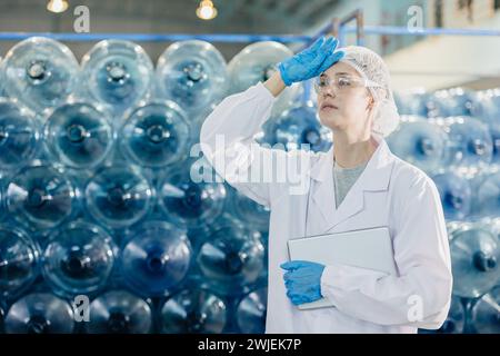 le donne adulte frenano rilassarsi lavorare in fabbrica di cibo e bevande acqua potabile lavoratore di impianti stanco gesto esausto. Foto Stock