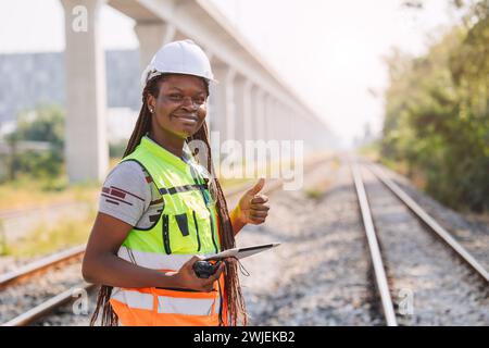 Ritratto ingegnere nero africano lavoratore lavoratore servizio di controllo in cantiere di binari ferroviari ferroviari nel settore dei trasporti Foto Stock