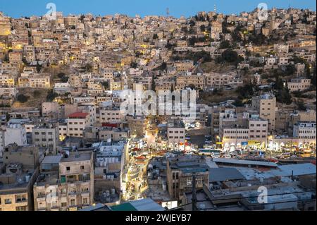Il vivace paesaggio urbano di Amman vanta un contrasto sorprendente di edifici torreggianti contro un pittoresco sfondo di montagne, che mostrano la bellezza dell'urba Foto Stock