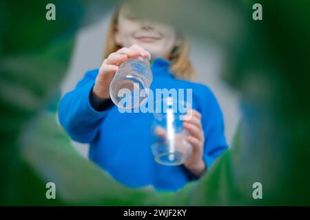 Visione ad angolo ridotto una famiglia di contenitori per lo smistamento delle bottiglie in plastica in casa. Smaltimento dei prodotti in bottiglia di latte. Foto Stock