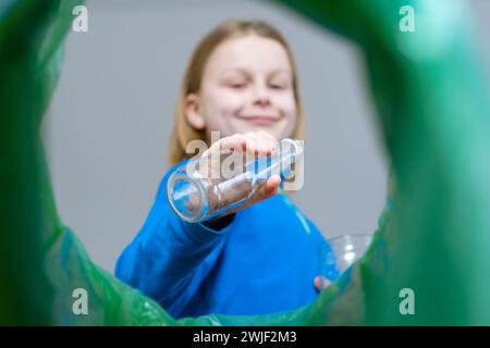 Visione ad angolo ridotto una famiglia di contenitori per lo smistamento delle bottiglie in plastica in casa. Smaltimento dei prodotti in bottiglia di latte. Foto Stock