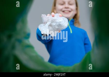 Sistema di riciclaggio e smistamento dei rifiuti per bambini con vista ad angolo basso avvolgimento di bolle in plastica in un cestino. Foto Stock