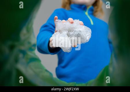 Sistema di riciclaggio e smistamento dei rifiuti per bambini con vista ad angolo basso avvolgimento di bolle in plastica in un cestino. Foto Stock