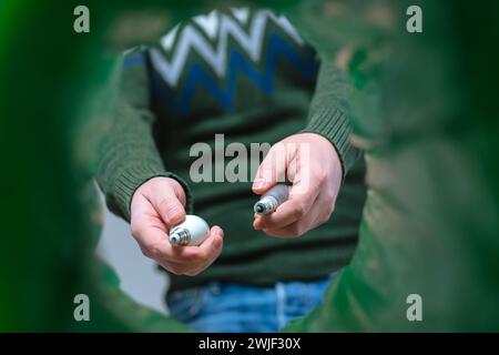 Mani con vista ad angolo basso per smistamento maschio di bottiglie in plastica nel cestino domestico. Riciclaggio delle lampade. Foto Stock