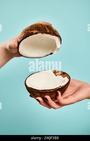 foto dell'oggetto di delizioso cocco fresco nelle mani di una giovane modella sconosciuta con smalto per unghie Foto Stock