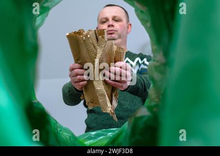 Carta kraft in rotolo maschio con vista ad angolo basso o confezione regalo in un contenitore dei rifiuti, concetto di riciclaggio e smistamento dei rifiuti. Foto Stock