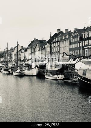 Le barche galleggiano pacificamente sull'acqua vicino agli edifici allineati sulla riva. Copenaghen Foto Stock