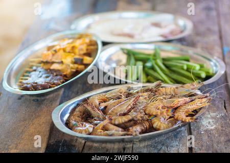 Grigliate di pesce sulla spiaggia. Aragosta, gamberi e barbecue di pesce. Pranzo salutare durante le vacanze estive al mare. Crostacei, calamari e gamberi grigliati sul fuoco. Foto Stock