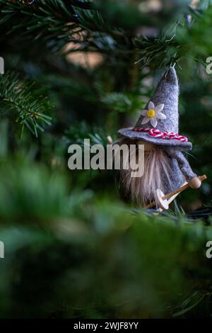 Uno gnomo sugli sci è appeso su un ramo di abete rosso come un giocattolo per l'albero di Natale Foto Stock