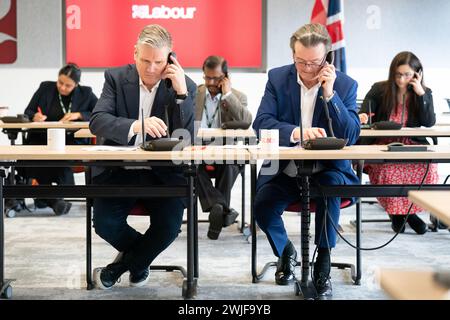 Il leader del lavoro Sir Keir Starmer (a sinistra) è affiancato dal musicista Feargal Sharkey che canvassola gli elettori telefonicamente per le elezioni suppletive di Wellingborough e Kingswood, presso il quartier generale laburista di Londra. Data foto: Giovedì 15 febbraio 2024. Foto Stock