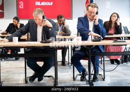 Il leader del lavoro Sir Keir Starmer (a sinistra) è affiancato dal musicista Feargal Sharkey che canvassola gli elettori telefonicamente per le elezioni suppletive di Wellingborough e Kingswood, presso il quartier generale laburista di Londra. Data foto: Giovedì 15 febbraio 2024. Foto Stock