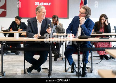 Il leader del lavoro Sir Keir Starmer (a sinistra) è affiancato dal musicista Feargal Sharkey che canvassola gli elettori telefonicamente per le elezioni suppletive di Wellingborough e Kingswood, presso il quartier generale laburista di Londra. Data foto: Giovedì 15 febbraio 2024. Foto Stock