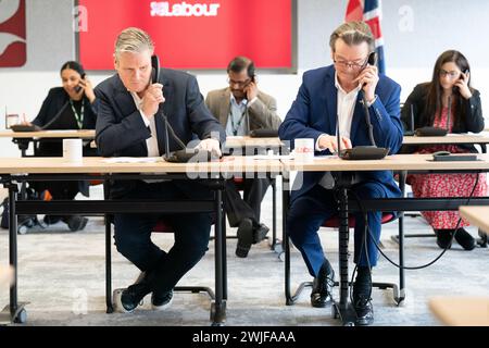 Il leader del lavoro Sir Keir Starmer (a sinistra) è affiancato dal musicista Feargal Sharkey che canvassola gli elettori telefonicamente per le elezioni suppletive di Wellingborough e Kingswood, presso il quartier generale laburista di Londra. Data foto: Giovedì 15 febbraio 2024. Foto Stock