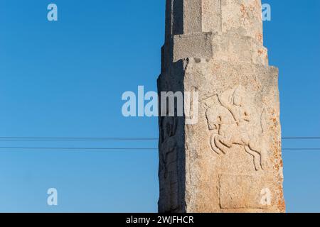 Questa immagine cattura gli intricati dettagli scolpiti di una storica colonna di pietra adagiata contro un cielo azzurro a Shravanabelagola, un importante pilone giainista Foto Stock