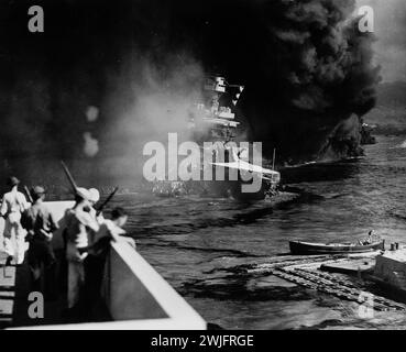 Seconda guerra mondiale - Pearl Harbor, Hawaii, 7 dicembre - colpito da bombe aeree e siluri, gli Stati Uniti California si sistemano lentamente nel fango e nel fango di Pearl Harbor Foto Stock