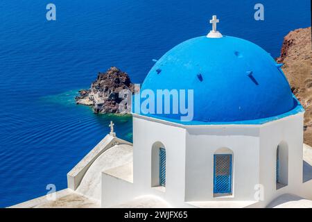 Tipica architettura bianca e blu con cupole e chiese del villaggio di Oia sull'isola di Santorini, Grecia. Foto Stock