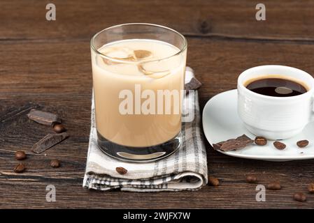 Un bicchiere di liquore Irish cream, una tazza di caffè nero e chicchi di caffè con cioccolato. Copia spazio. Foto Stock