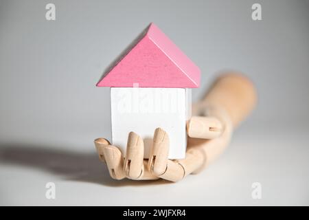 Modello che tiene a mano i blocchi giocattolo a forma di un hous, concetto di immobili e costruzione di case Foto Stock