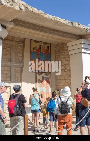 Palazzo di Minosse, Cnosso, Creta, Grecia. Un gruppo di turisti che ammirano l'affresco della "Processione" nel Propileo Sud. Foto Stock