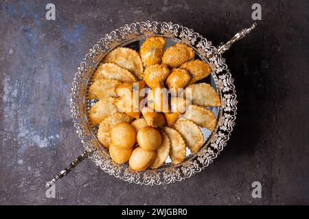 Un assortimento di deliziosi pasticcini, tra cui baklava, borek e boureka, è disposto ad arte su un piatto d'argento. Foto Stock