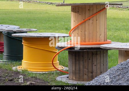 Cavo su tamburi di legno con campo in erba dietro le quinte in Svezia, Scandinavia Foto Stock