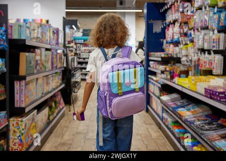 Studentessa con una nuova borsa scolastica al negozio di cancelleria Foto Stock