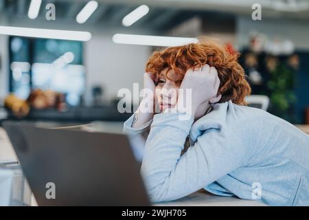 Dopo una giornata impegnativa in ufficio, l'adorabile dipendente rossa ha faticato a rimanere sveglio. Foto Stock