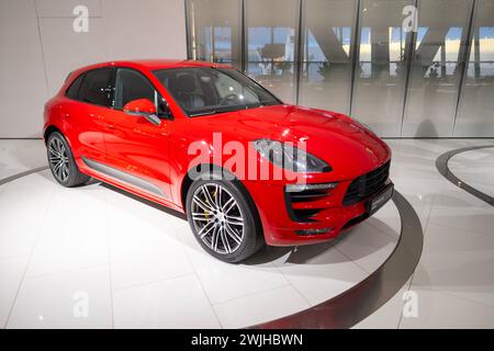 Nuova Porsche Macan Turbo rossa, trazione integrale 4x4, Elegance Sports Car in showroom, sviluppo sostenibile, innovazione nel settore automobilistico Porsche Foto Stock