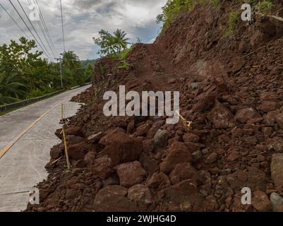 Frana di montagna a causa di forti piogge. Fango e rocce sul lato destro della strada. Filippine. Foto Stock
