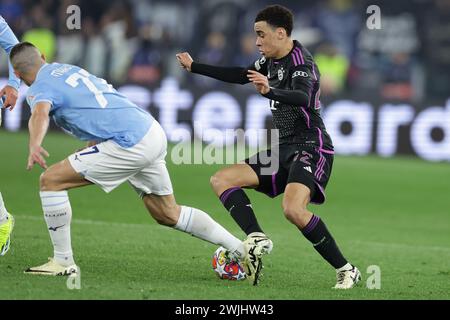 Il difensore serbo della Lazio Adam Marusic sfida per il pallone con il centrocampista tedesco del Bayern Monaco Jamal Musiala durante il turno di UEFA Champions League 16, partita di andata tra SS Lazio e Bayern Monaco a Roma, il 14 febbraio 2024. Foto Stock