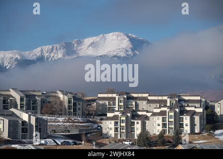 Una tempesta invernale sgorga sul Pikes Peak a Colorado Springs. Appartamenti, case a schiera e condomini ai piedi offrono splendide viste sulle montagne. Foto Stock