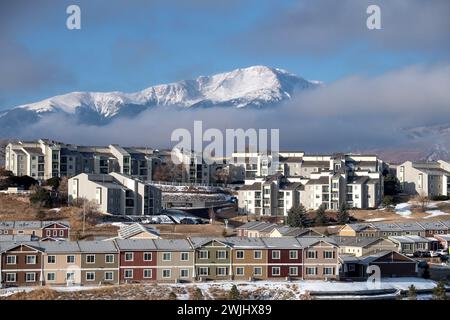Una tempesta invernale sgorga sul Pikes Peak a Colorado Springs. Appartamenti, case a schiera e condomini ai piedi offrono splendide viste sulle montagne. Foto Stock