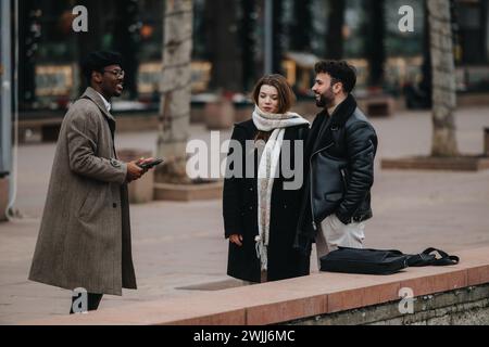 Riunione aziendale urbana: Giovani imprenditori che discutono di lavoro all'aperto. Foto Stock