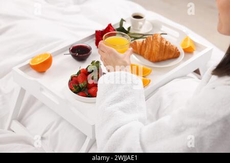 Donna che fa colazione a letto a casa, primo piano Foto Stock