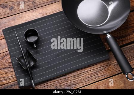 Ferro da stiro vuoto, ciotola per la salsa e bacchette su un tavolo di legno Foto Stock