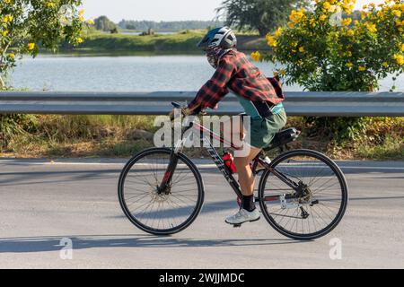 SAMUT PRAKAN, THAILANDIA, DEC 15 2023, Un ciclista corre su una strada del villaggio Foto Stock