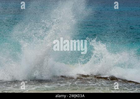 Infrangere le onde sulle rocce vicino alla riva, grandi spruzzi, Mahe Seychelles Foto Stock