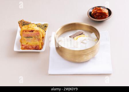 Tteokguk, pancake e kimchi sono in una ciotola Foto Stock