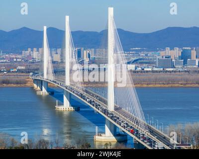 NANJING, CINA - 16 FEBBRAIO 2024 - Un gran numero di veicoli guida lentamente sul ponte del fiume Yangtze di Nanjing Jiangxinzhou, prov. Jiangsu Foto Stock