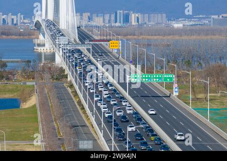 NANJING, CINA - 16 FEBBRAIO 2024 - Un gran numero di veicoli guida lentamente sul ponte del fiume Yangtze di Nanjing Jiangxinzhou, prov. Jiangsu Foto Stock