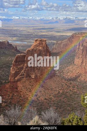 spettacolare arcobaleno in una soleggiata giornata primaverile sul monumento all'indipendenza e sulle scogliere del monumento nazionale del colorado, fruita, colorado Foto Stock