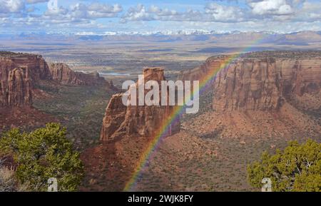 spettacolare arcobaleno in una soleggiata giornata primaverile sul monumento all'indipendenza e sulle scogliere del monumento nazionale del colorado, fruita, colorado Foto Stock