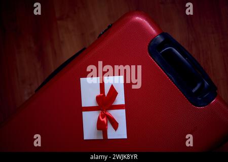buono omaggio nei colori rosso e bianco su una valigia rossa per viaggiare Foto Stock