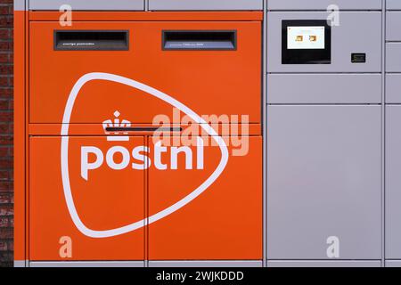 Servizio postale PostNL olandese, servizio di ritiro e consegna automatico dei pacchi. armadietti accessibili 24 ore su 24 per pacchi e posta con logo arancione Foto Stock