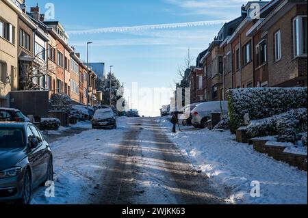 Dilbeek, Brabante fiammingo, Belgio - 18 gennaio 2024 - strada residenziale collinare coperta di neve Foto Stock