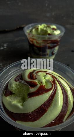 La foto è una foto di gelato al gusto di avocado in una tazza con sfondo nero Foto Stock